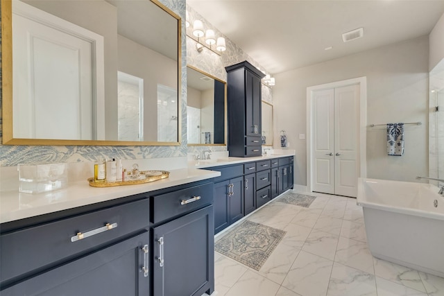 bathroom featuring a freestanding tub, visible vents, marble finish floor, a sink, and double vanity