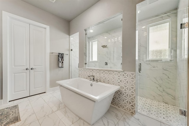 bathroom with a marble finish shower, a soaking tub, and marble finish floor