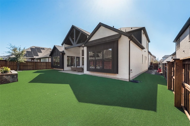 back of property with brick siding and a fenced backyard