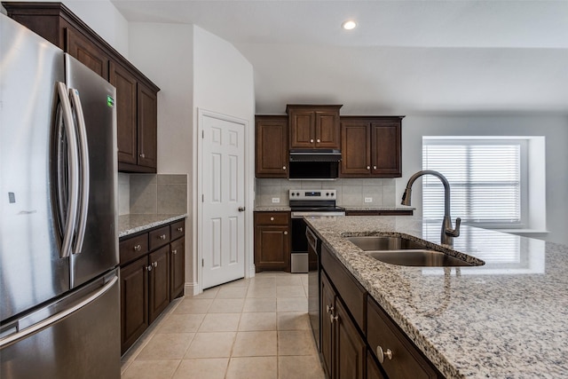 kitchen with light tile patterned flooring, a sink, decorative backsplash, stainless steel appliances, and dark brown cabinets