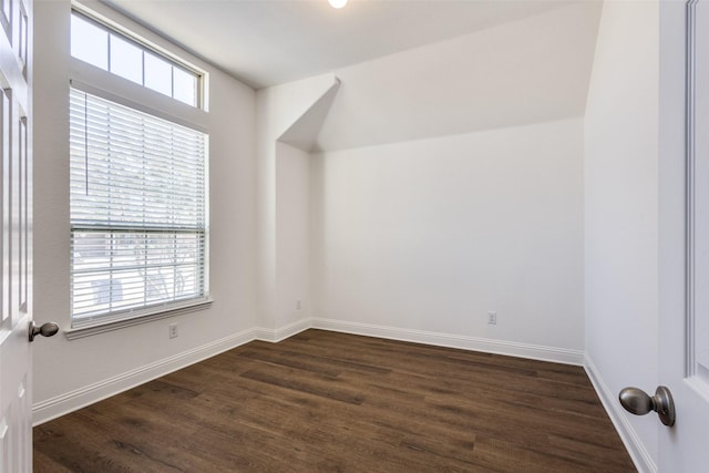 bonus room featuring dark wood-type flooring and baseboards