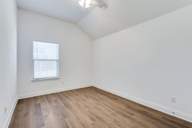 unfurnished room featuring ceiling fan, baseboards, wood finished floors, and vaulted ceiling