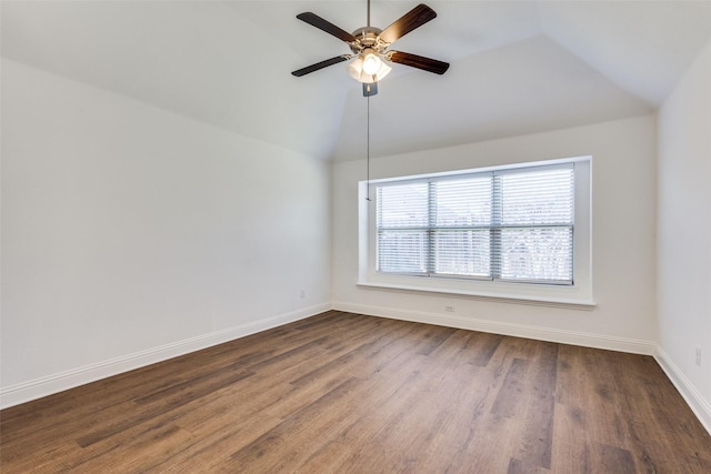 unfurnished room with vaulted ceiling, dark wood-style floors, baseboards, and ceiling fan