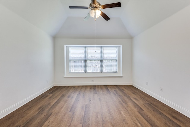 spare room with ceiling fan, baseboards, lofted ceiling, and dark wood-style flooring