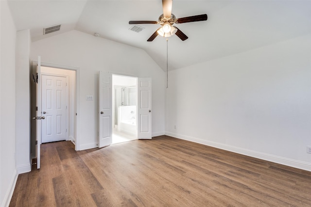 unfurnished bedroom with visible vents, lofted ceiling, baseboards, and wood finished floors