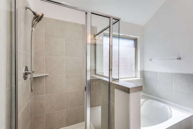 bathroom with a stall shower and a garden tub