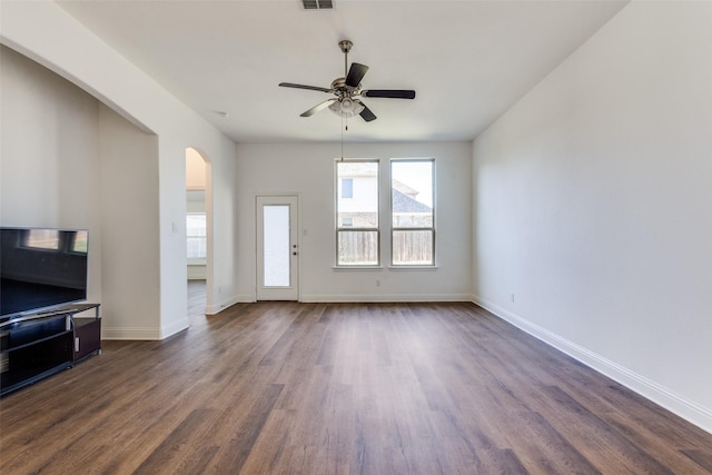 living room with visible vents, dark wood finished floors, arched walkways, baseboards, and ceiling fan