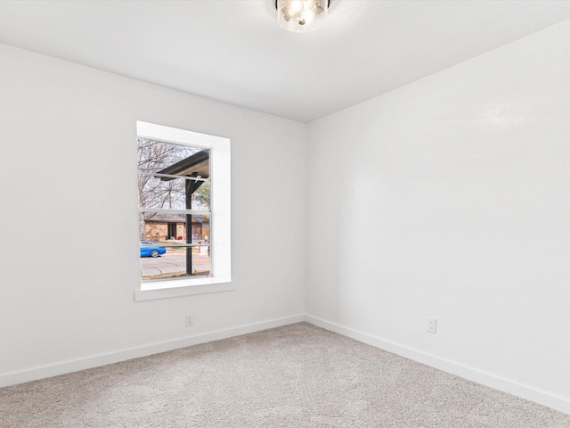 carpeted empty room featuring baseboards