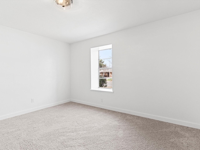 carpeted spare room featuring baseboards