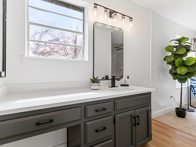 bathroom with vanity, wood finished floors, and baseboards