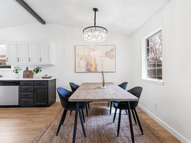 dining space featuring plenty of natural light, vaulted ceiling with beams, light wood-style floors, and an inviting chandelier