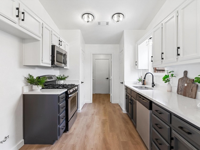 kitchen with light countertops, visible vents, appliances with stainless steel finishes, and a sink