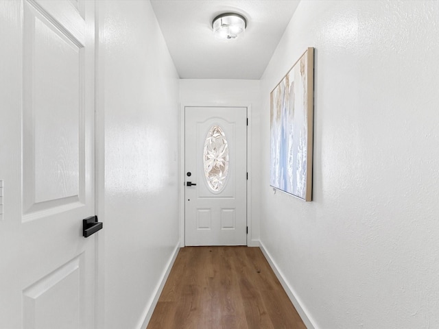 entryway featuring baseboards and dark wood-type flooring