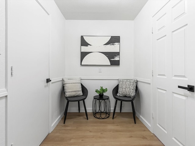 sitting room with light wood-type flooring and baseboards