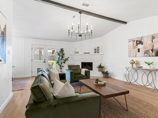 living area with lofted ceiling with beams, visible vents, light wood-type flooring, and french doors