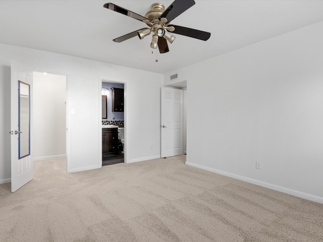 unfurnished bedroom with visible vents, ensuite bathroom, baseboards, light colored carpet, and ceiling fan