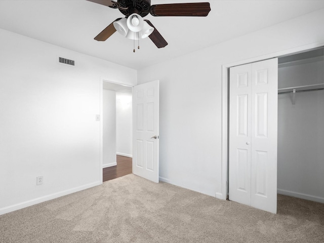 unfurnished bedroom featuring visible vents, baseboards, carpet floors, a closet, and a ceiling fan