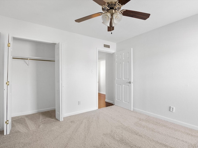 unfurnished bedroom with baseboards, visible vents, carpet floors, and a closet