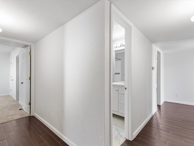 hall with baseboards and wood finished floors