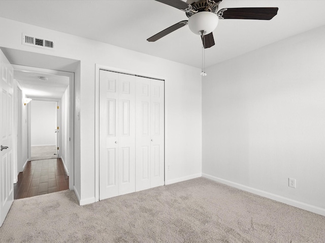 unfurnished bedroom with visible vents, ceiling fan, baseboards, carpet, and a closet