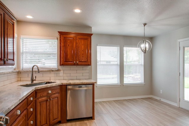 kitchen featuring light wood finished floors, tasteful backsplash, brown cabinets, stainless steel dishwasher, and a sink