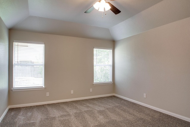 carpeted spare room featuring baseboards, ceiling fan, and vaulted ceiling