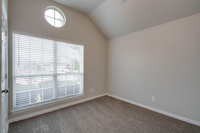 carpeted empty room featuring lofted ceiling