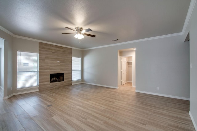 unfurnished living room featuring baseboards, visible vents, light wood finished floors, ceiling fan, and a tiled fireplace