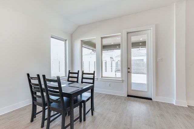 dining area with lofted ceiling, light wood-style flooring, and baseboards