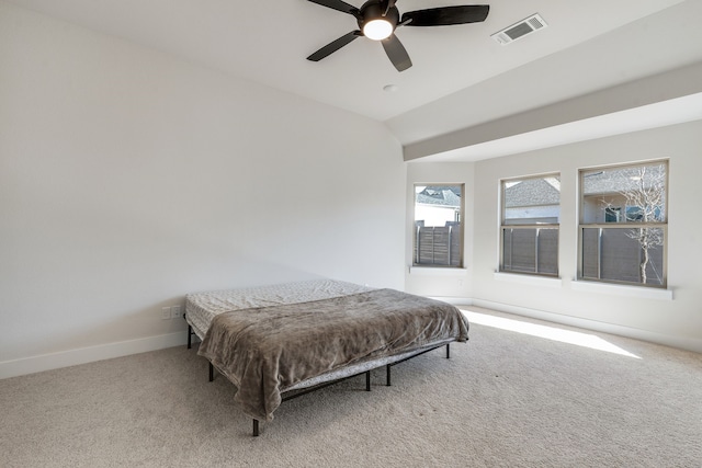 bedroom with visible vents, a ceiling fan, carpet floors, baseboards, and vaulted ceiling