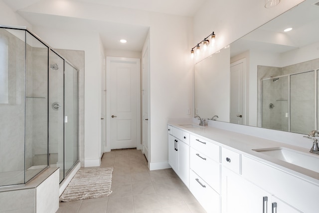 full bathroom featuring tile patterned flooring, a stall shower, and a sink