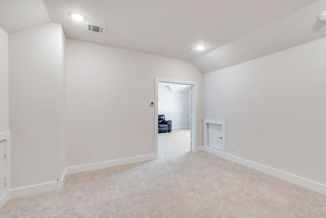 empty room with visible vents, baseboards, carpet, and vaulted ceiling