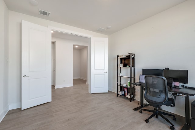 office area featuring baseboards, visible vents, and light wood finished floors