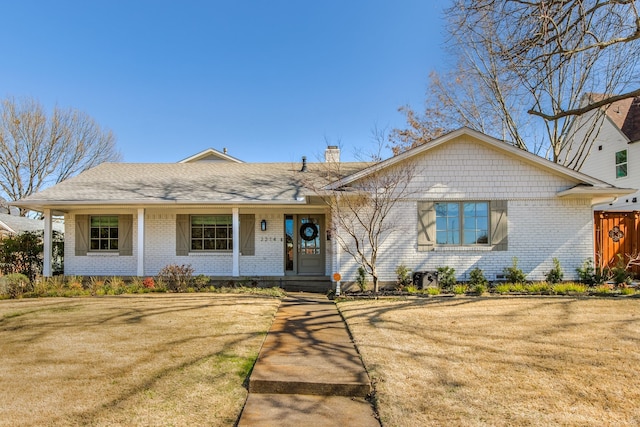 ranch-style house featuring a front yard, brick siding, and a chimney