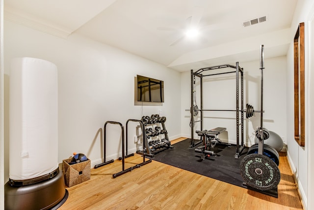 exercise area with a ceiling fan, wood finished floors, visible vents, and baseboards