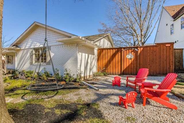 view of property exterior featuring fence and brick siding