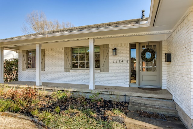 property entrance featuring brick siding and covered porch