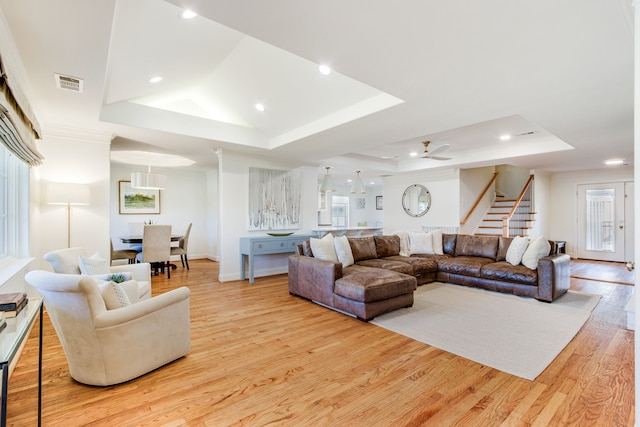 living area with visible vents, recessed lighting, stairway, light wood finished floors, and a raised ceiling