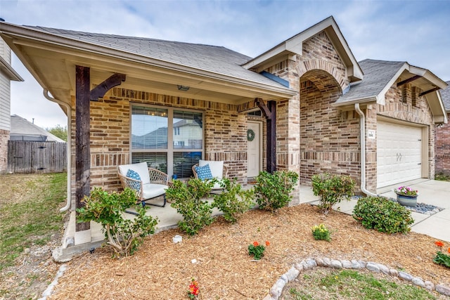 view of front of house featuring a garage, brick siding, concrete driveway, and fence