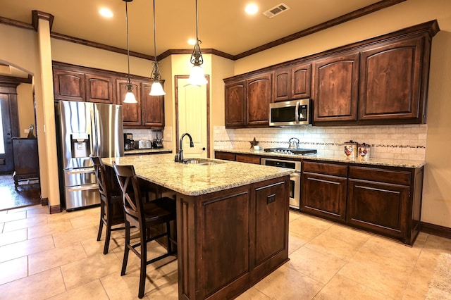 kitchen with visible vents, a sink, backsplash, dark brown cabinetry, and appliances with stainless steel finishes