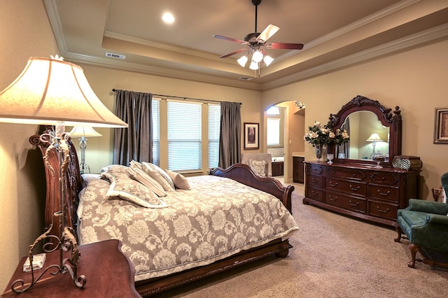 bedroom with visible vents, a raised ceiling, carpet, and crown molding