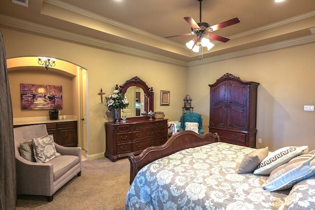 bedroom featuring a ceiling fan, visible vents, crown molding, a raised ceiling, and light colored carpet