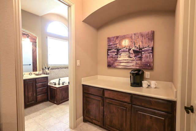 full bath featuring vanity and a garden tub