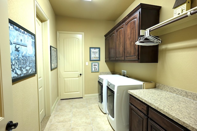 washroom with baseboards, cabinet space, and washing machine and dryer