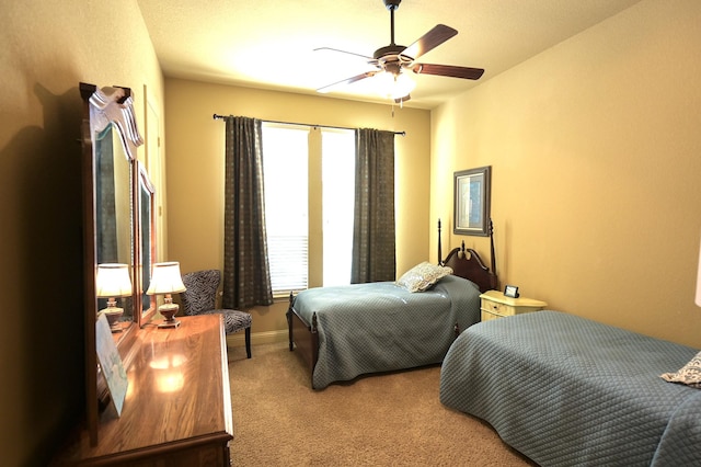 bedroom with ceiling fan, baseboards, and carpet