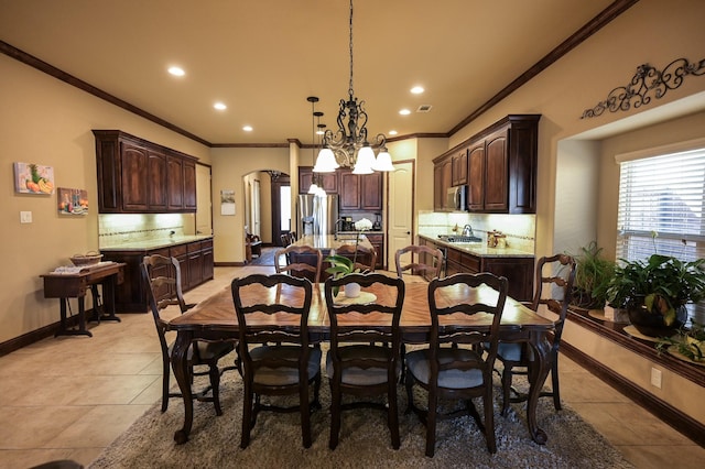 dining room with crown molding, baseboards, an inviting chandelier, light tile patterned flooring, and arched walkways