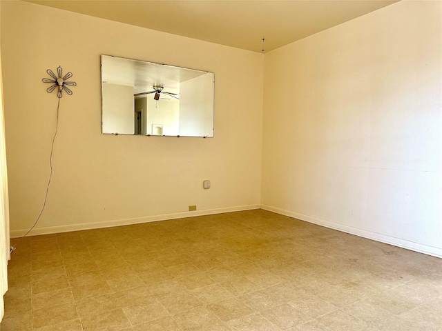 spare room with baseboards and light floors