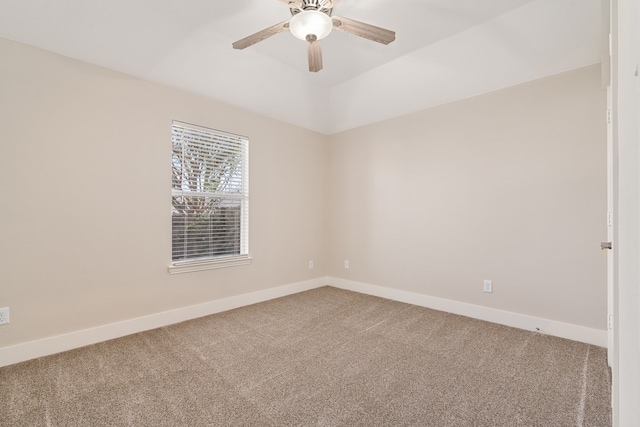 carpeted spare room featuring ceiling fan and baseboards