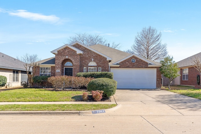 view of front of property with a front yard, driveway, an attached garage, a shingled roof, and brick siding