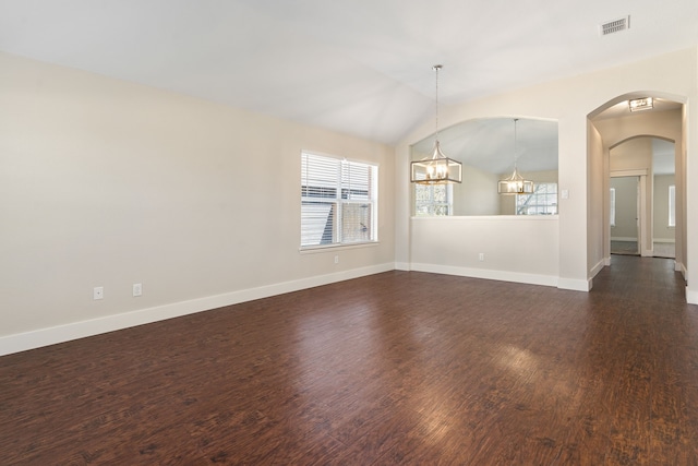 unfurnished room featuring dark wood-style floors, baseboards, visible vents, vaulted ceiling, and a chandelier